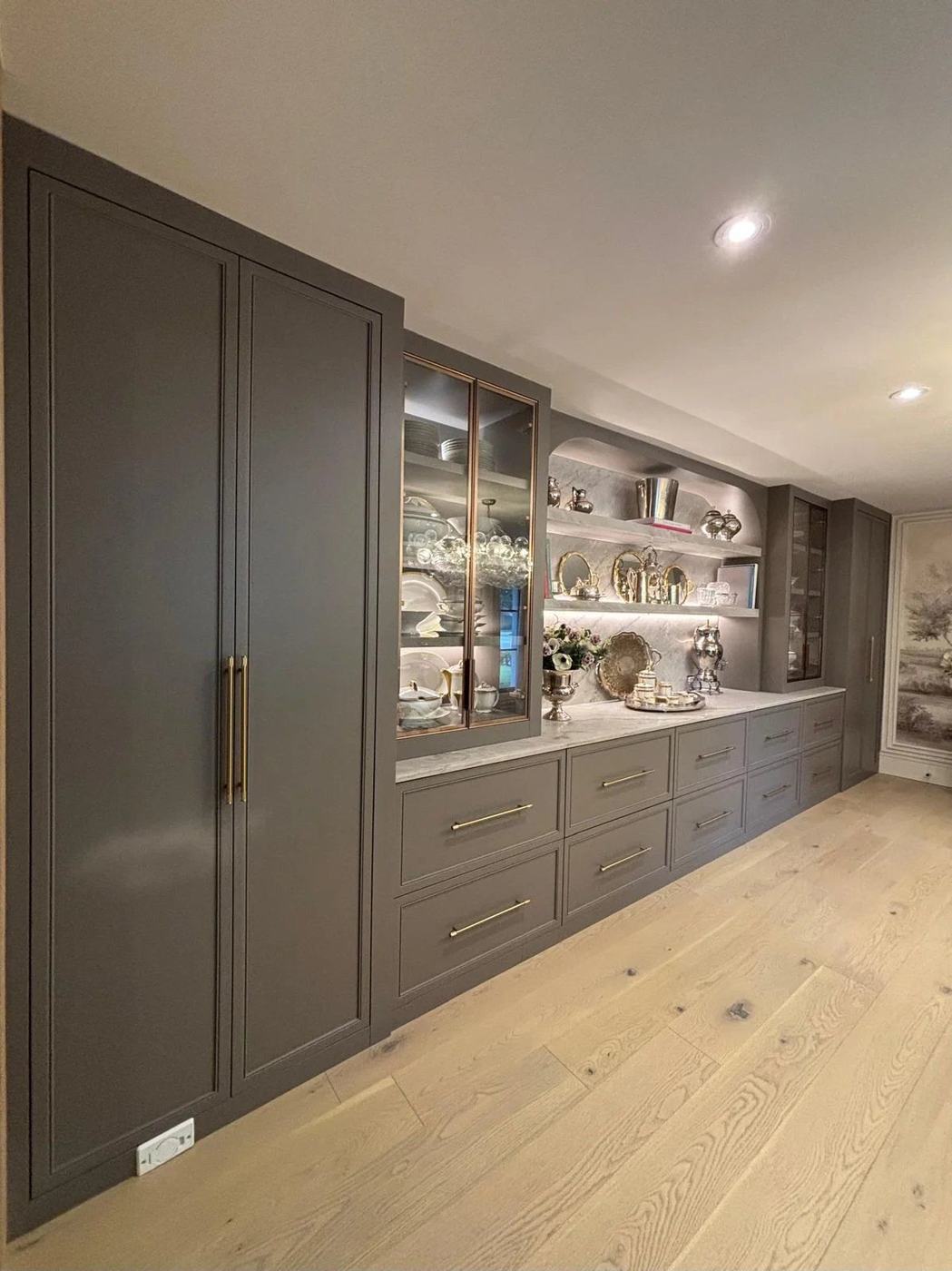 Custom built-in wall cabinets with glass display doors, lit shelving and brass hardware in Kleinburg, by NewGen Renovations Vaughan