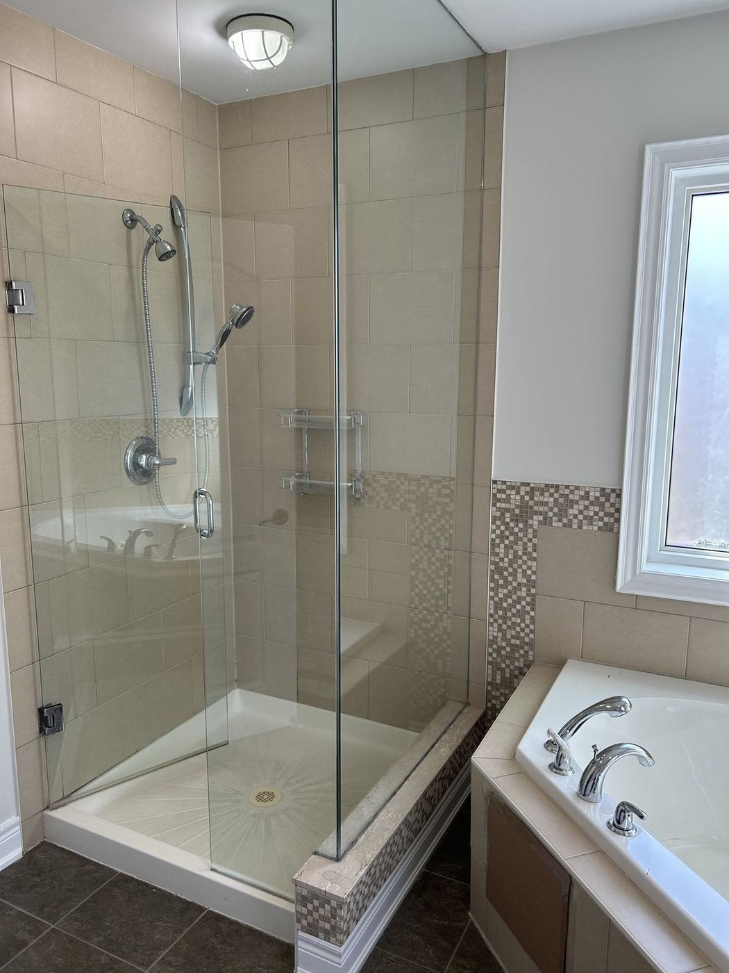 Dated beige tile shower and corner tub before a bathroom renovation by NewGen Renovations Vaughan